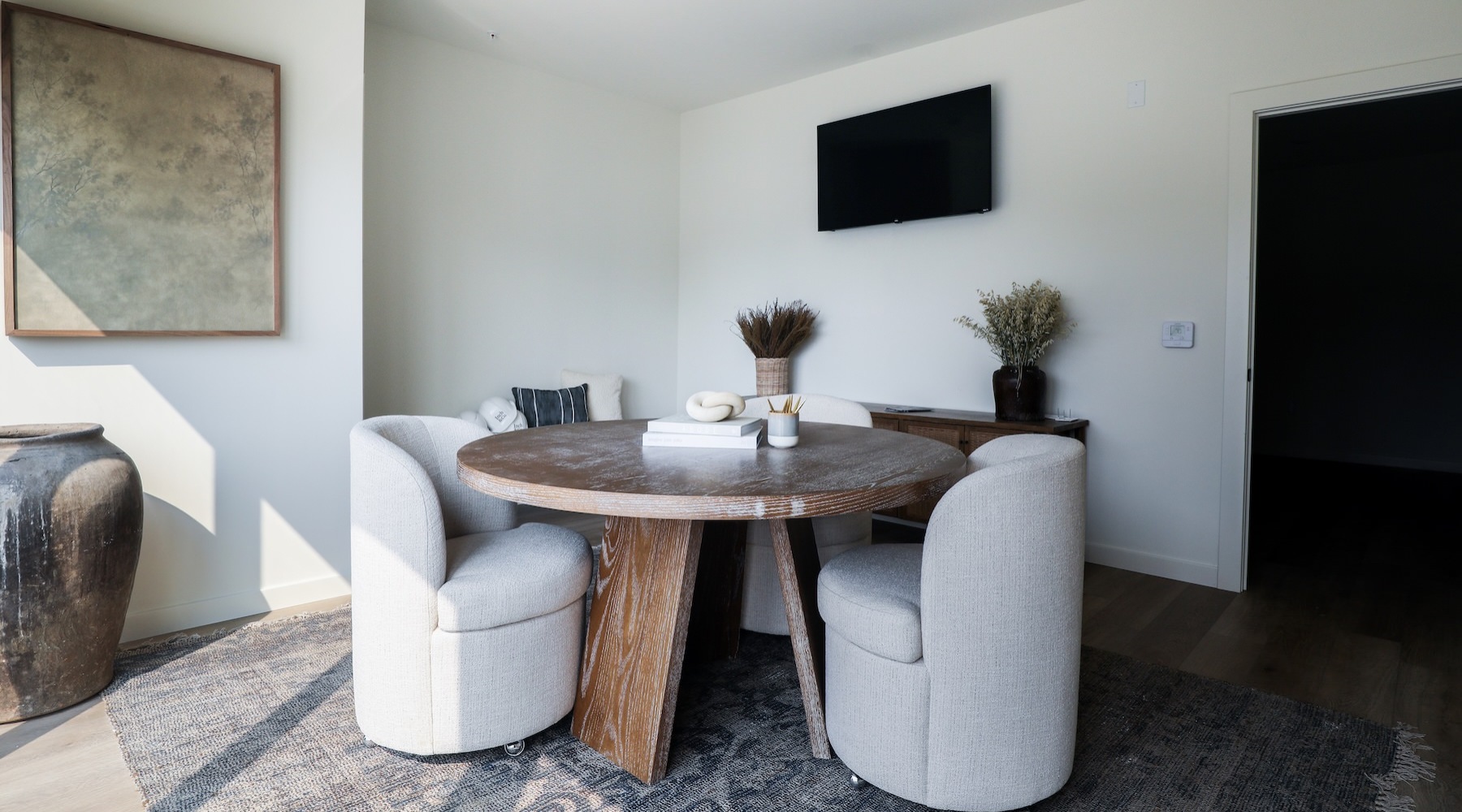 a room with a tv, table and chairs